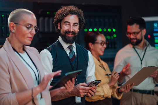 Diverse team of it specialists collaborating in a server room, managing network infrastructure and cloud computing operations