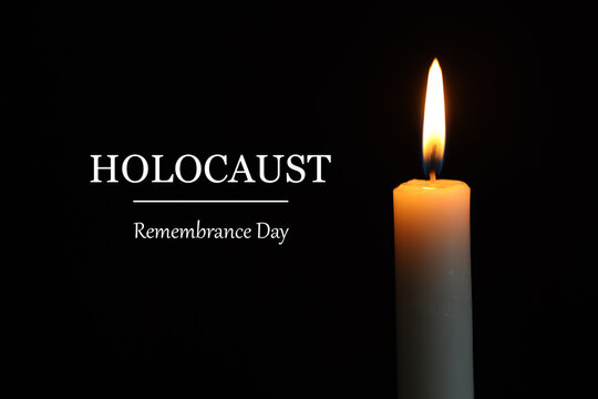 Holocaust Remembrance Day. Burning candle on black background