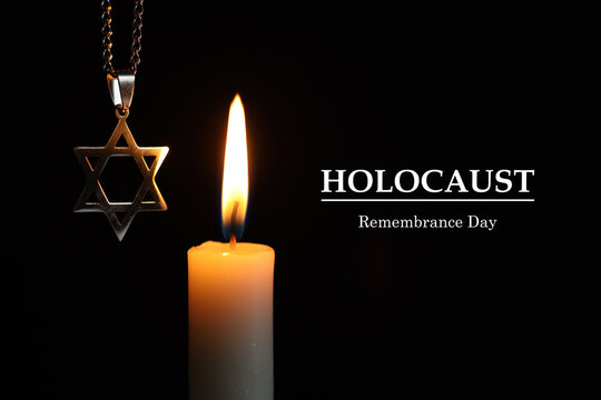 Holocaust Remembrance Day. Star of David pendant and burning candle on black background