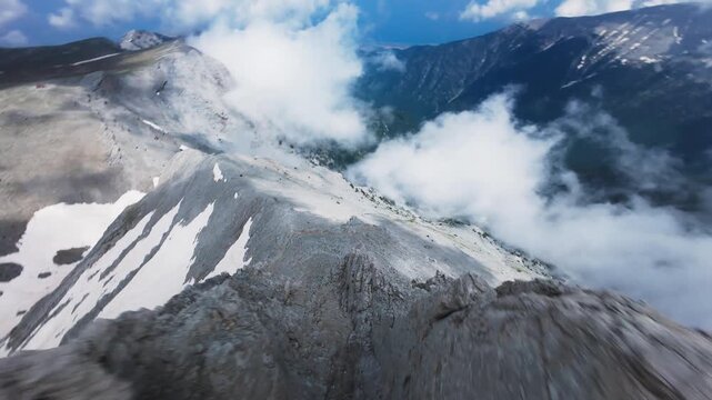 Dynamic FPV drone shot diving along sharp crest of Mount Olympus Greece