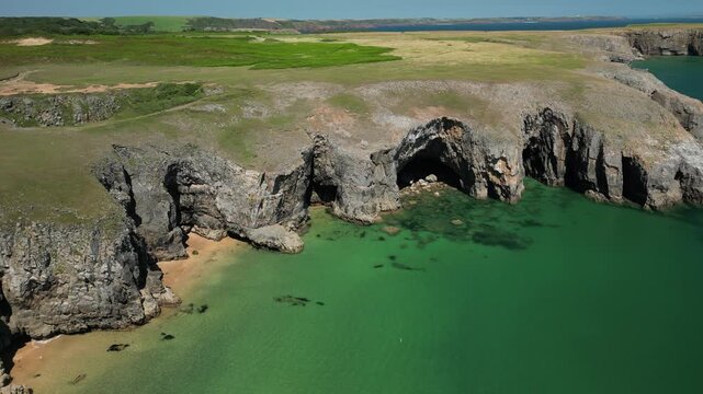 The view of cliffs surrounded by turquoise water in Pembrokeshire - drone flight