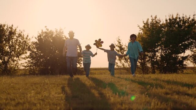 boy girl Child kid mother father child walking sunset park, parents children walking run holding hands, children playing colorful pinwheel, parent child relationship, children chasing dreams