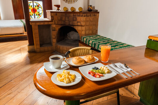Healthy Breakfast Spread on Wooden Table in Cozy Cabin Kitchenette with Scrambled Eggs, Fruit, and Coffee