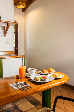 Healthy Breakfast Spread on Wooden Table in Cozy Cabin Kitchenette with Scrambled Eggs, Fruit, and Coffee