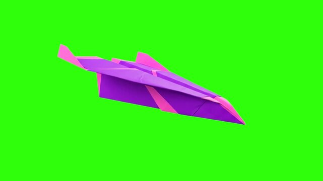 Bright pink and purple folded origami paper airplane flying diagonally across a solid green screen chroma key background. Ideal for travel agency promotions, message delivery concepts, creative child-