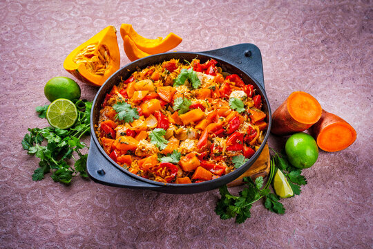 Slow cooked casserole dish healthy yummy spicy Italian one-pan role stew vegetable pumpkin, sweet potato, chicken and rice served as close-up in a design pan