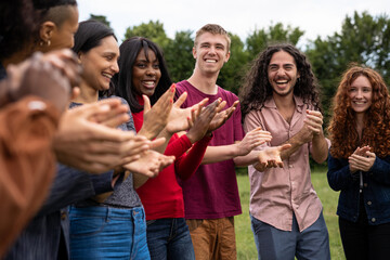 Fototapeta premium Multiracial Friends Clapping Hands in Celebration Outdoors