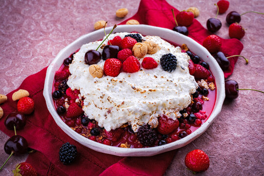 Oven baked meringue ricotta souffle with mixed fresh berries and amarettinis served as dessert