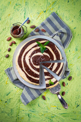Naklejka premium Artisan homemade baked zebra black-white cheesecake pie with dark chocolate served as top view on a design plate