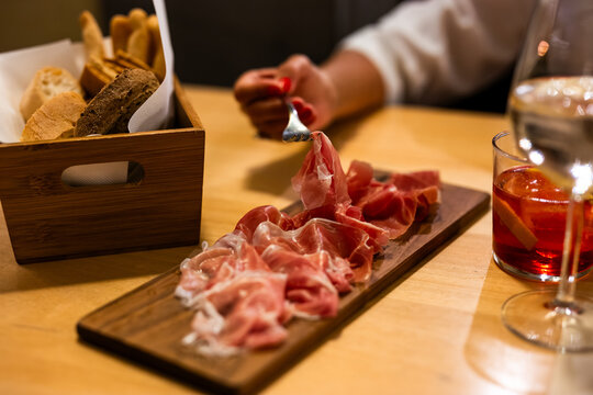 Italian aperitivo with charcuterie board prosciutto salami and red Negroni cocktail at bar