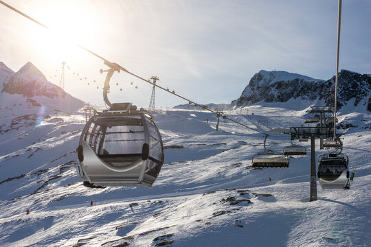 New modern spacious big cabin Kaprun ski lift gondola against snowcapped forest tree and mountain peaks covered snow landscape luxury winter alpine resort. Winter leisure sports, recreation travel.
