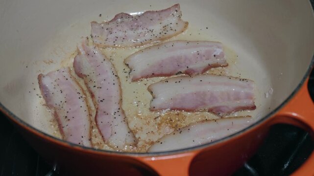 Peppered bacon rendering in an enameled cast iron Dutch oven