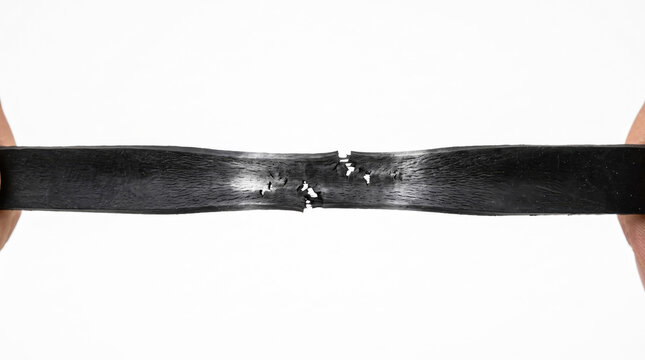 Hands stretching a cracking and breaking black rubber band