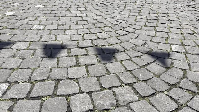 Abstract Background of Shifting Shadows from Hanging Flags Fluttering in the Wind on Cobblestone Pavement, Ideal Overlay Texture for Video Backgrounds and Motion Graphics, Sunny Day