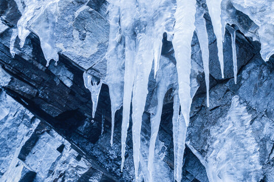 Hanging Icicles on Rocky Cliff Surface in Winter &mdash; Ice Cave Detail
