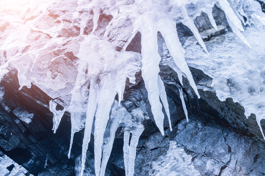 Hanging Icicles on Rocky Cliff Surface in Winter &mdash; Ice Cave Detail