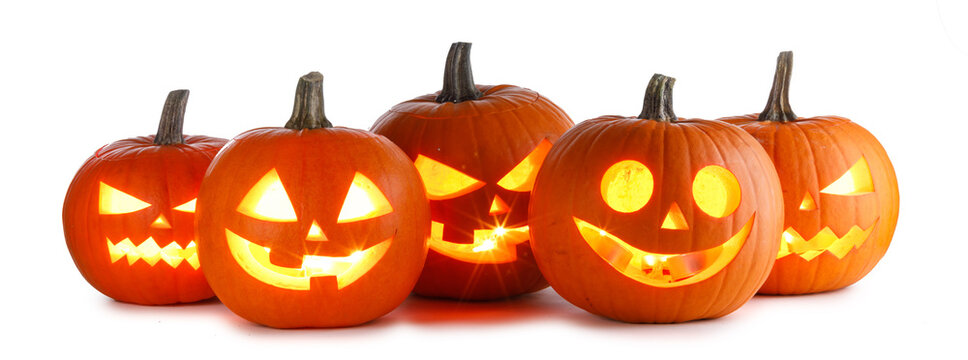 Carved Halloween pumpkins with scary faces illuminated from inside