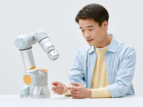 産業用ロボットアームを操作するエンジニア