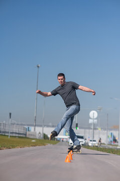 A Caucasian man rollerblades around the slalom course.