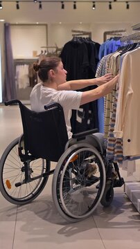 A Caucasian woman in a wheelchair shopping at a mall. 