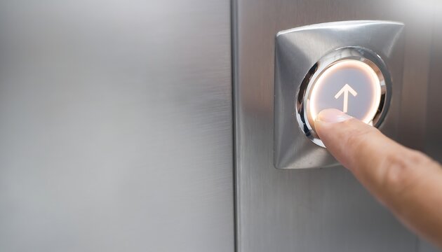 A close up of a finger pressing an elevator button to go up.