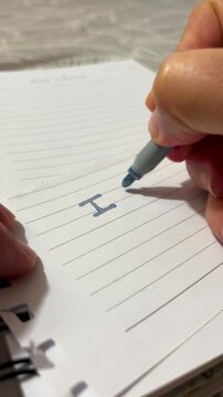 A close-up of a handwriting the message 'I love you' on a torn piece of paper. 24fps vertical video.