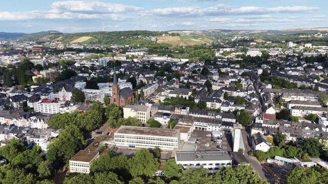 Drone aerial panorama of Trier, Germany, featuring the historic Roman Bridge over the Moselle River, the old town skyline, tree-lined waterfront and surrounding hills. Scenic summer cityscape showcasi