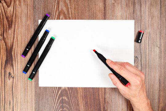 person holding a marker over a sheet