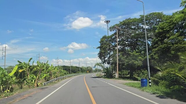 Driving on country road in rural, Singburi province Thailand.