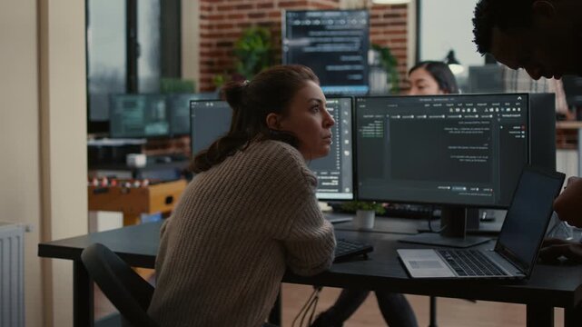 Junior software developer presents source code on a laptop for colleague opinion, supporting collaborative debugging and professional feedback