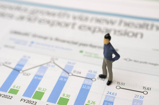 Miniature Businessman Figure Standing on Financial Growth Chart for Business Strategy