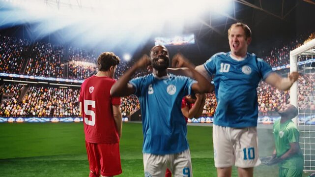 Happy diverse football players celebrating winning goal on pitch, with arms raised and clenched fists, devastated opponents while rivals hugging teammates.