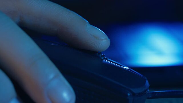 Extreme Close-Up of Finger Clicking Computer Mouse in Blue Lighting, Ideal for themes related to technology, internet browsing, gaming, office work, digital interaction, and computer usage.