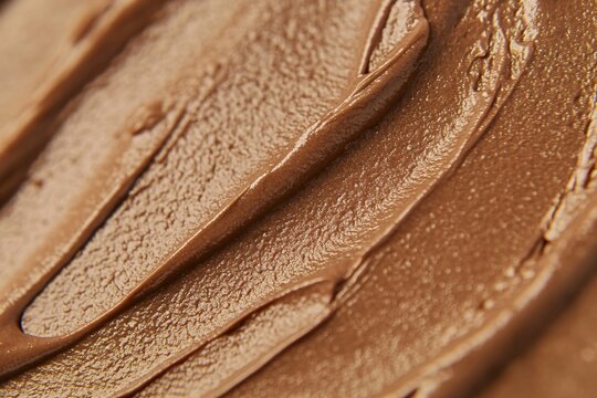Brown chocolate texture macro background. Creamy spread surface with smooth ridges for appetizing culinary design. Sweet food ingredient close up wallpaper and graphic element decoration.