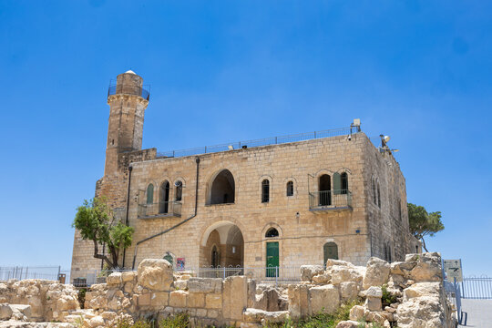 Exterior view of the historic stone structure at Nebi Samwil (Kever Shmuel) featuring its prominent tower under a clear blue sky.