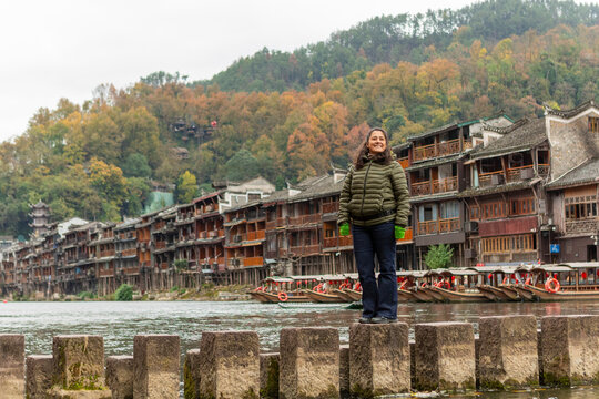 Woman traveling Fenghuang ancient town stepping stones