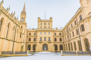 Obraz premium Exterior view of the neo-Gothic Lednice Castle covered with snow, a UNESCO World Heritage site in Czechia.
