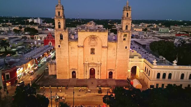 Illuminated Merida Cathedral aerial view descending at dusk