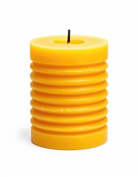 A cylindrical, textured yellow candle stands lit against a white background