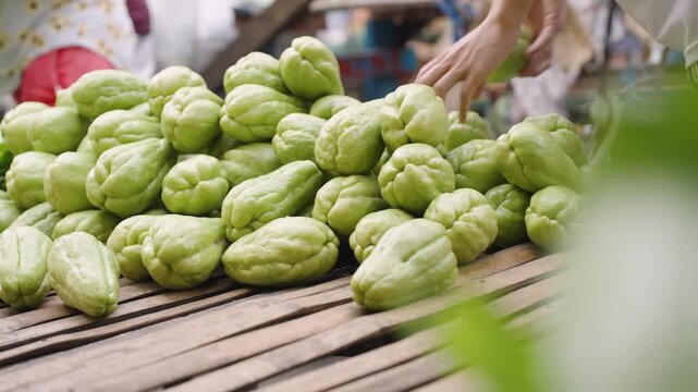 Vendor Arranging Fresh Chayote at a Local Market