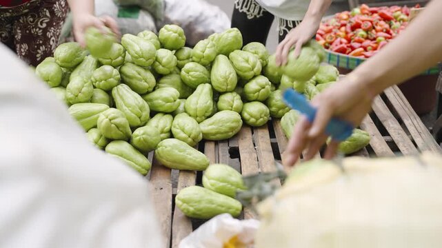 Vendors Arranging Fresh Chayote at a Local Market