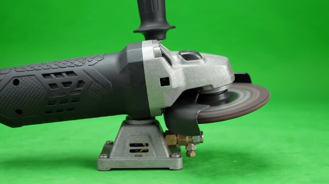 Industrial pneumatic air grinder tool with spinning disc isolated on chroma key green screen