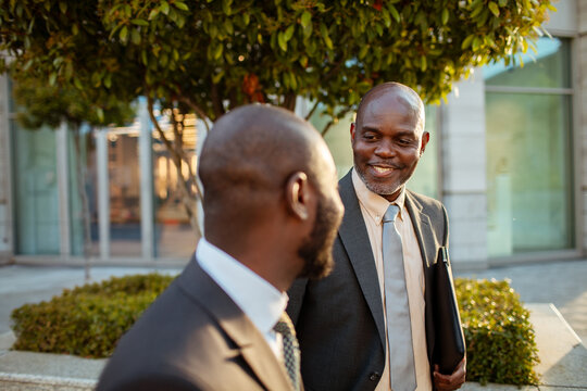 Two business professionals talking outside office building