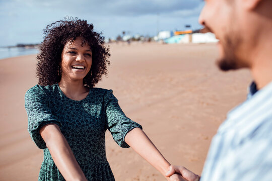 Happy couple holding hands on beach