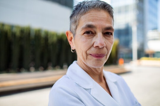 Confident senior doctor portrait outside hospital