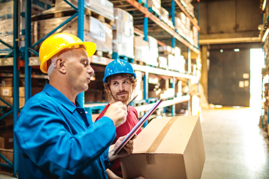 Supervisor and worker reviewing shipment in warehouse