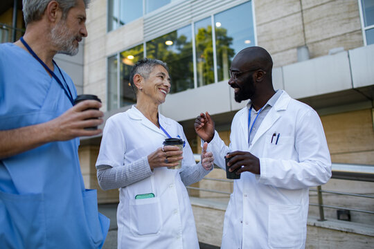 Smiling doctors talking during coffee break outside hospital