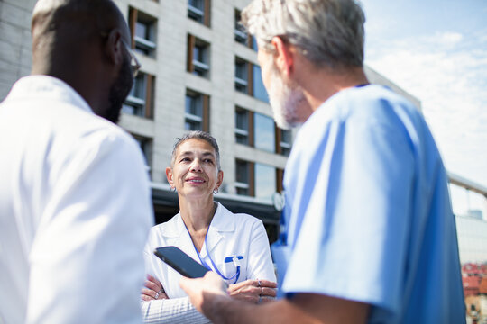 Doctors discussing patient care outside hospital