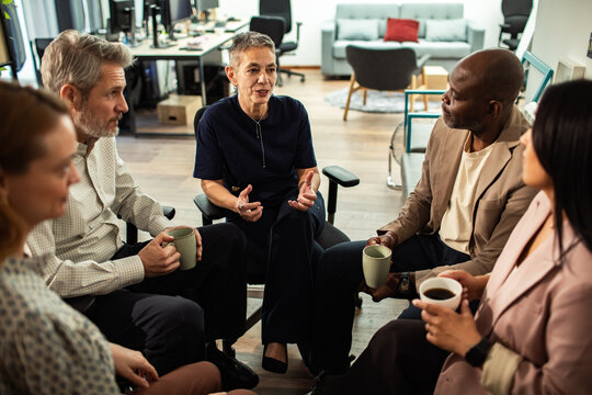 Diverse coworkers having a circle discussion in a modern office
