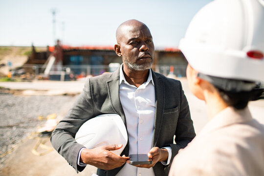 Project manager talking with engineer at construction site